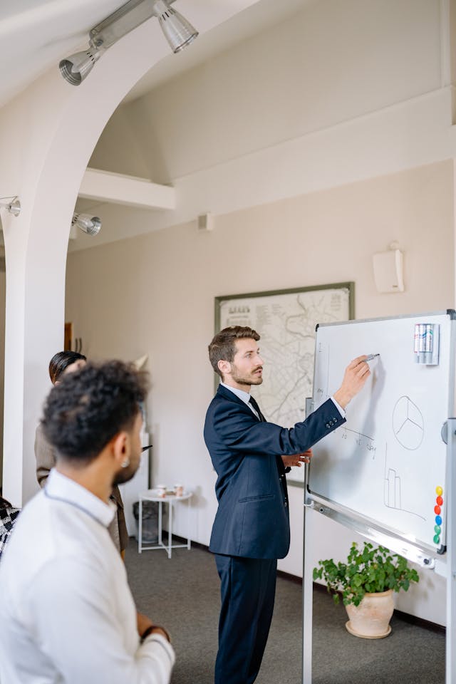 Illustrative image Man in Corporate Attire Discussing in Front used in Accordemy®'s training on Community Forums Management