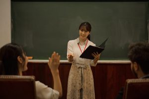 Illustrative image A Teaching Looking Toward a Student Raising Their Hand used in Accordemy®'s training on Training of Master Trainers (ToMT): Level 3 of the TDP
