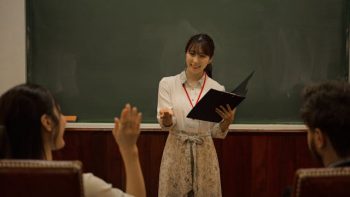 Illustrative image A Teaching Looking Toward a Student Raising Their Hand used in Accordemy®'s training on Training of Master Trainers (ToMT): Level 3 of the TDP